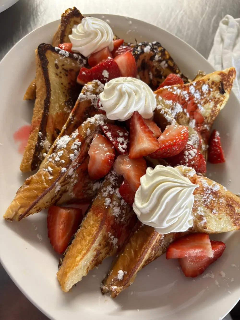 French toast with fresh strawberries, whipped cream and icing sugar