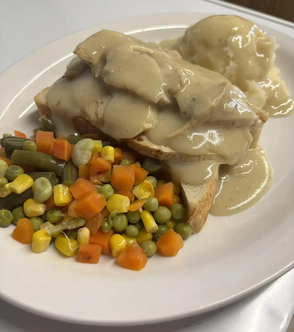 Hot turkey on bread with mashed potato, gravy and mixed vegetables